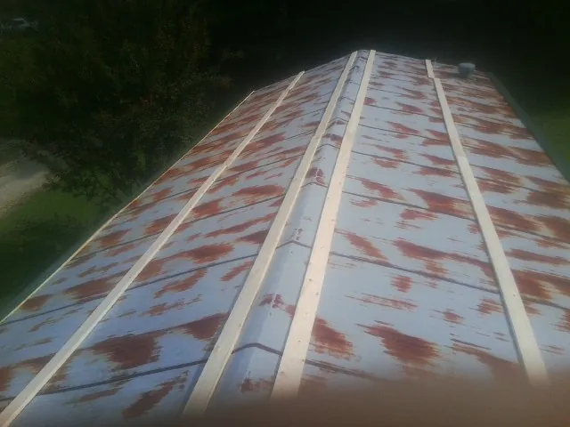 Rusted metal roof panels with new wood purlins before replacement — Storm Damage Roof Repair in Stuart by Roofing Brothers